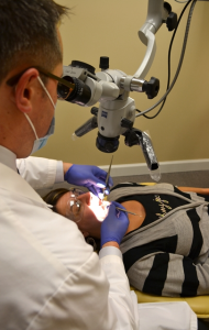 Foto de un endodoncista realizar un retratamiento endodóntico